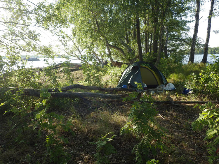 Bild. Mitt tält på en liten ö i kvällssol.