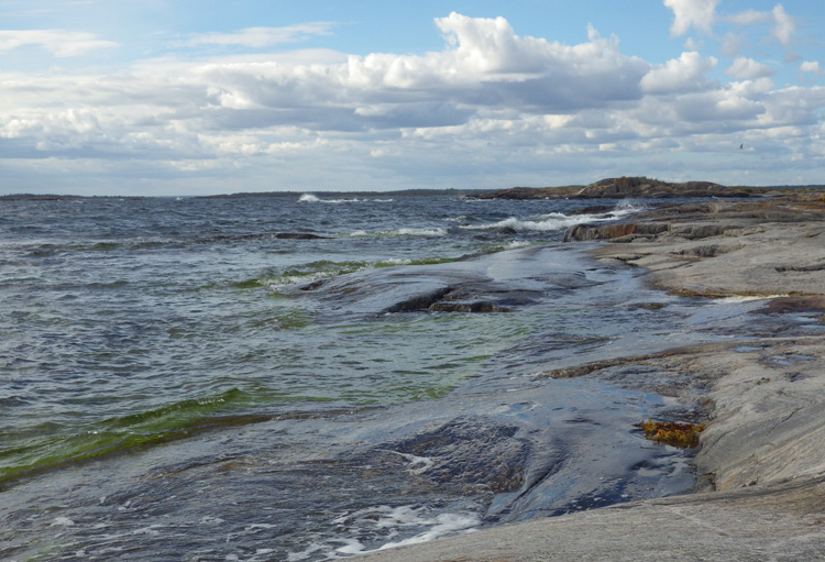 Bild. Stranden på Garkast. Vågorna slår upp.