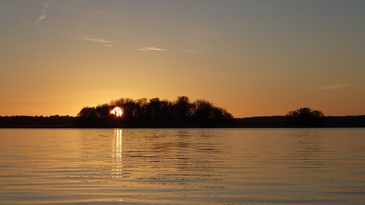 Bild. Solen går ner bakom en ö