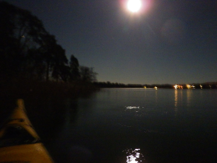 Bild. Måne, Ö i förgrunden. Avlägsna ljus.
