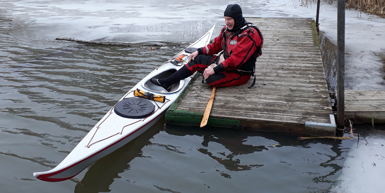 Bild. Jag sitter på bryggan med en fot i kajaken.