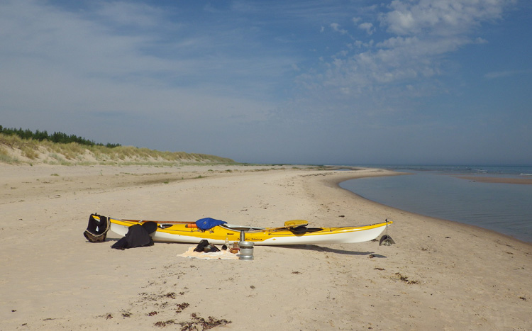 Bild. Min kajak på bred sandstrand.